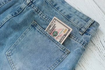A bill of 50 dollars on a denim background in a pocket