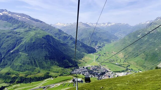 Travel in Overhead Cable Car over the Swiss Alps and Cityscape in a Sunny Summer Day in Andermatt, Uri, Switzerland. (Time Lapse)