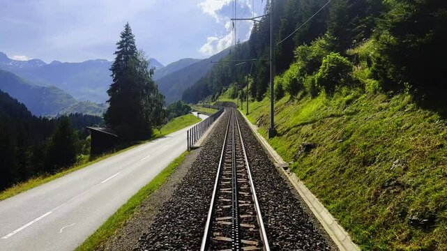 Rear View From the Glacier Express Train on Railroad Tracks in a Sunny Summer Day in Sedrun, Surselva, Oberalp, Grisons, Switzerland.