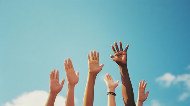 Diverse hands reaching up towards the sky, expressing unity, diversity, hope, and communal aspirations under a clear blue sky.