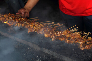 Sate Ayam (Chicken Satay) grilled on hot charcoal grill.