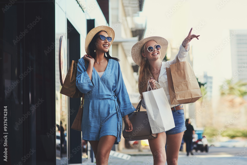 Wall mural Pointing, friends and happy women with shopping bags in city for fashion sunglasses, discount or luxury clothes. Black Friday, girls or gift outdoor at mall for retail, street promotion or sales deal