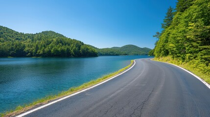 Winding Road Alongside Serene Forest Lake