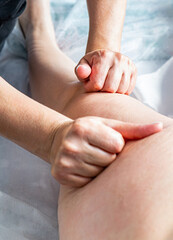 Masseur makes anti-cellulite massage on the legs, thighs, hips and buttocks in the spa. Overweight treatment, body sculpting.Cosmetology and massage concept.