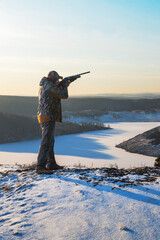  hunter aiming with a gun. winter hunting.