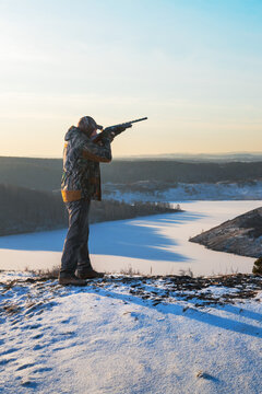  hunter aiming with a gun. winter hunting.