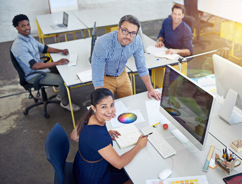 Above, office and employees with smile for teamwork or collaboration and coworking with strategy. Business, people and happy as graphic designers on computer with pride for creative ideas and plan - Powered by Adobe
