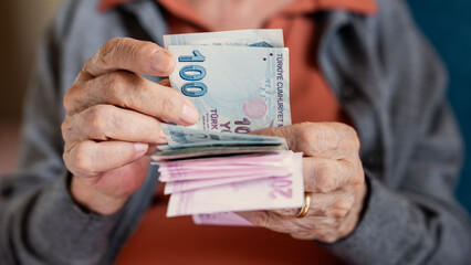 Old woman counting Turkish lira banknotes