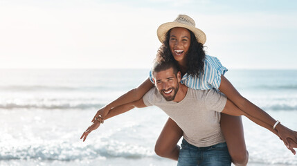 Couple, happy and piggyback at beach for travel, summer and tropical holiday together in San Diego. Man, woman and carrying on sand by ocean for adventure, love and relax on vacation with portrait
