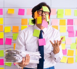 Young employee in conflicting priorities concept