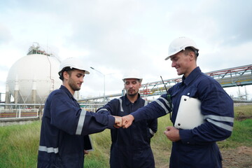 Three male engineers, technicians, shook hands and worked together to succeed and inspect the oil...