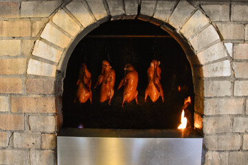 Peking duck roasting on an open fire in a restaurant in Beijing