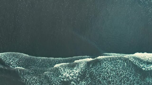 Barrido de olas blancas que crean un efecto de s&aacute;banas en la arena que es captado por un drone en 4k. Este espect&aacute;culo natural se crea desde las alturas y toca la arena amarilla, azul y atardeceres.