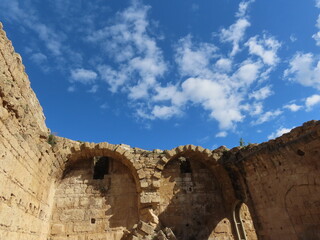 Ruins of an ancient city in Caesarea in Israel against a background of blue sky and white clouds. An interesting journey through historical sights.