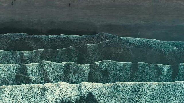 Barrido de olas blancas que crean un efecto de s&aacute;banas en la arena que es captado por un drone en 4k. Este espect&aacute;culo natural se crea desde las alturas y toca la arena amarilla, azul y atardeceres.