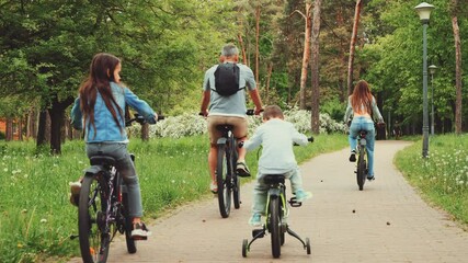 Family riding bicycles through a scenic forest park, enjoying an active outdoor experience together. Concept of family bonding, outdoor activities, and a healthy lifestyle - Powered by Adobe