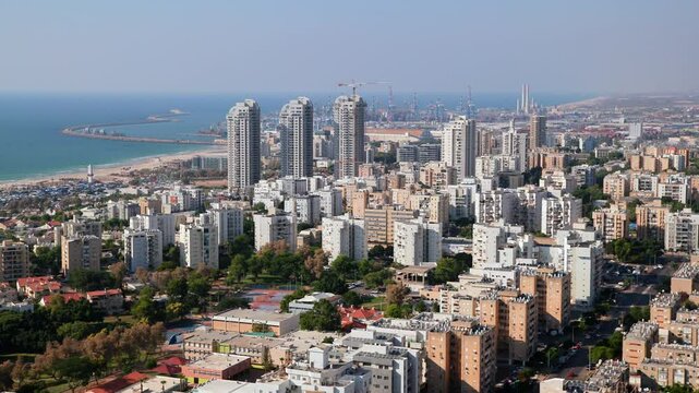 A city Ashdod view from a high building with many tall buildings and a large body of water in the background. High quality 4k footage