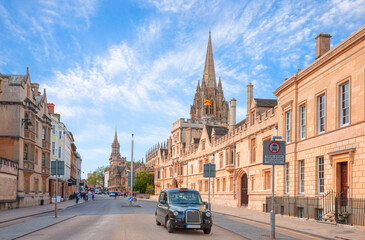 Obraz premium View of High Street road with Cityscape of Oxford - Typical black british taxi cab 