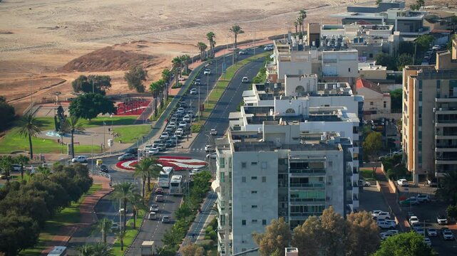 Street by the sea shore in Ashdod. A city street with a large white building in the middle. The street is busy with cars and buses. High quality 4k footage