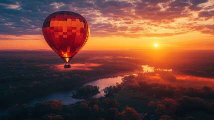 Obraz premium A vibrant hot air balloon floats over a serene landscape during a breathtaking sunset, ideal for travel promotions and adventure-themed advertisements,