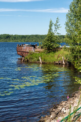 The hull of an abandoned old ship on the river bank.