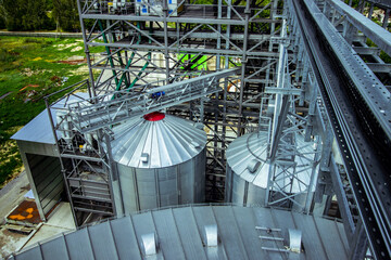 Agricultural Facility with Large Grain Silos. A vast agricultural facility with large grain silos, essential for the storage and management of harvested crops in modern farming.