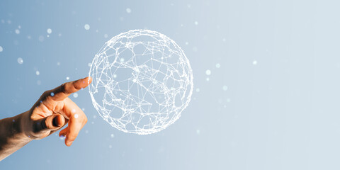 Hand pointing at digital wireframe globe on light blue background, representing global connections...