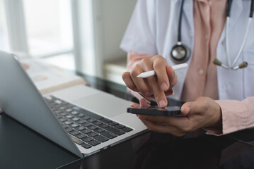 Doctor using smartphone at medical clinic for wellness research, medical app and online consulting....