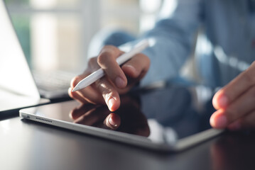 Close up of woman hand using digital tablet, surfing the internet, searching the information,...