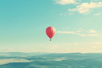 Obraz premium Hot air balloon floating in blue sky over hills