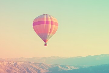 Fototapeta premium Hot air balloon soaring over mountains at sunrise.