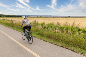 Femme cycliste sur la véloroute des Bleuets - obrazy, fototapety, plakaty
