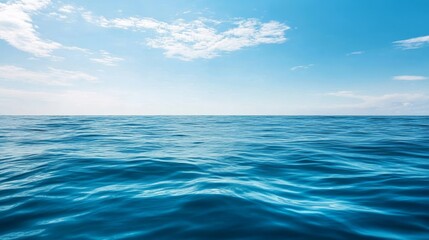 Obraz premium Calm ocean water reflecting a clear blue sky, creating a serene and tranquil atmosphere perfect for relaxation and inspiration.