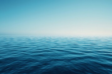 Obraz premium Serene view of a calm ocean with gentle waves under a clear blue sky, perfect for relaxation and nature-themed projects.