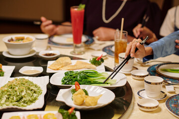 Close-up of people eating Chinese food during meeting in the restaurant