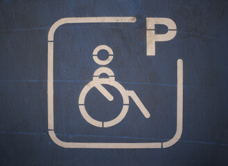 A wheelchair logo in blue indicates a space reserved for disabled people in a public car park