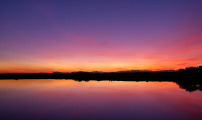 Obraz premium the reflection of a sunset in a lagoon