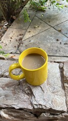 Yellow coffee cup on stone surface