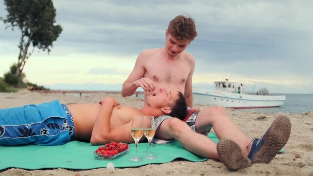 Relaxed young men on a romantic date during their seaside vacation, they relax and have fun on the beach.
