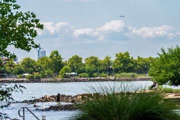 This photo showcases a tranquil riverside park in Jersey City, where lush greenery meets the calm...