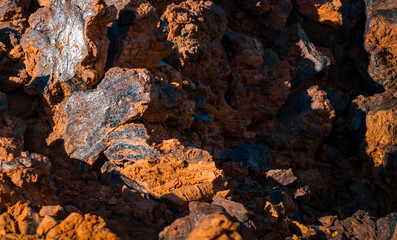 Lava formations, stones, black basalt in the rocks closeup on a volcano terrain.