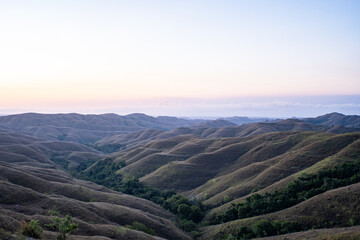 スンバ島で夕陽が当たる緑色の山