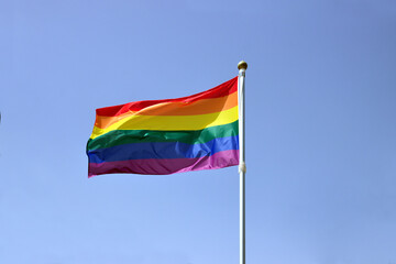 LGBT flag on the blue sky moved by the wind, with copy space