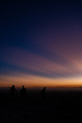 夕陽が沈むグラデーションの空と人のシルエット