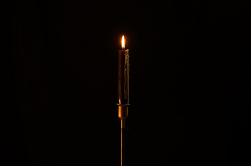burning candle on black background. Dark candle burning on a candlestick.