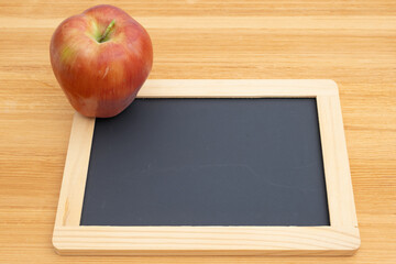 Back to School with a blank chalkboard and apple on a desk