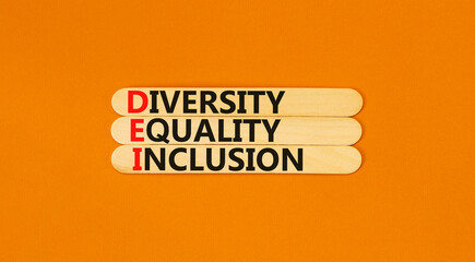 DEI diversity equality inclusion symbol. Concept words DEI diversity equality inclusion on stick. Beautiful orange background. Business DEI diversity equality inclusion concept. Copy space.