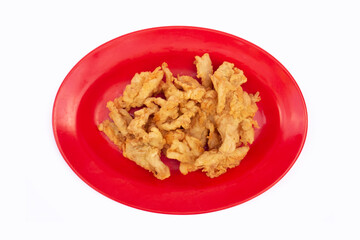 Krispi Fried Oyster Mushrooms or Krispi Mushrooms. Oyster mushrooms wrapped in seasoned flour and dry fried. fried mushrooms on a red plate with a white background.