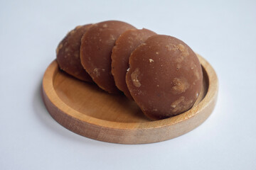 Close up of palm brown sugar on a wooden plate. Palm sugar in half-ball shape.