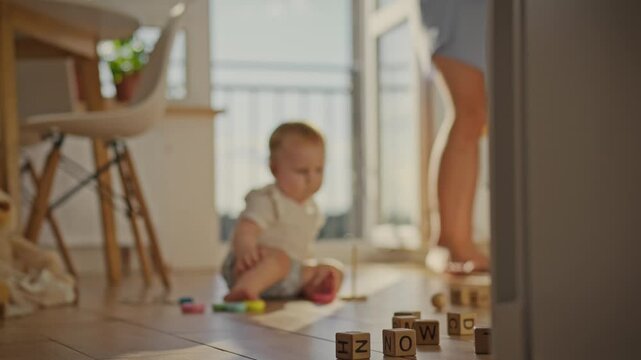 A young housewife steps barefoot around the house. A small child is playing on the floor, while the mother slowly walks around the kitchen. The camera focuses on the girl's legs in close-up